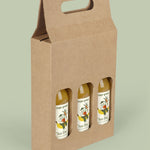 Cardboard bottle carrier with three bottles inside on a light green background